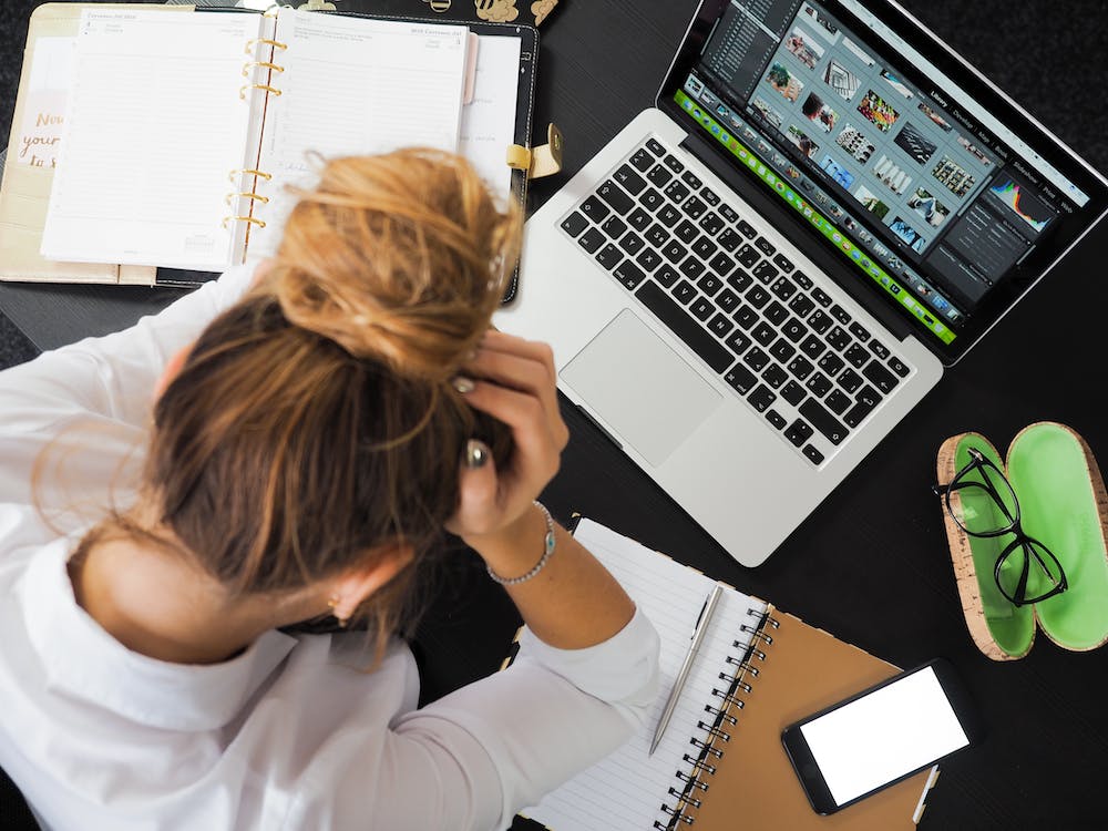 Woman looking stressed at a computer.