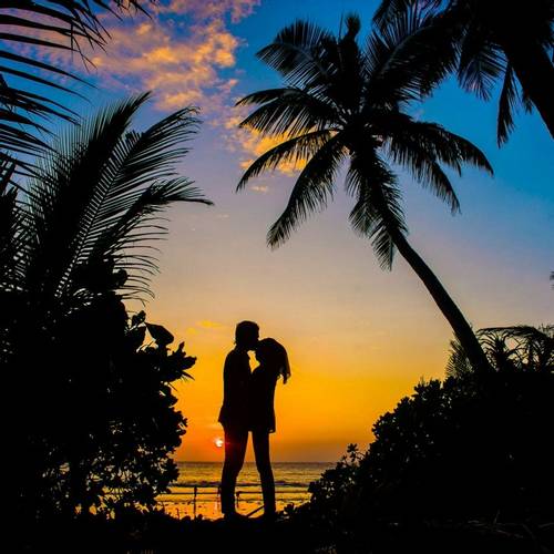 Silhouetted couple on a beach in the Maldives at Sunset
